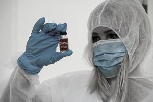 chercheur dans Hazmat protecteur costume examiner une tester tube dans le chimique laboratoire. photo