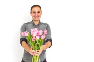 homme en portant tulipes. cadeau carte modèle, affiche ou salutation carte - homme en portant bouquet de tulipes pour une femme. de la mère jour, la Saint-Valentin jour, aux femmes journée concept. 8 de Mars cadeau photo