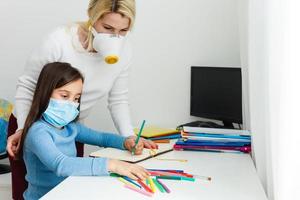 mère et fille dans protecteur masque faire devoirs à distance Accueil scolarité, quarantaine photo