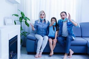 famille sur le canapé en train de regarder la télé à maison. rester à Accueil pendant quarantaine photo