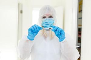 chercheur dans Hazmat protecteur costume examiner une tester tube dans le chimique laboratoire. photo