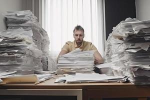 homme au milieu de piles de papiers sur fils bureau photo