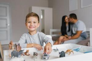 enfant garçon en jouant avec jouets dans le garderie contre le Contexte de le sien content Parents photo