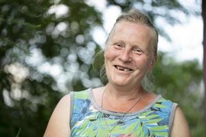 portrait de un personnes âgées femme avec or les dents en riant et à la recherche à le caméra. photo