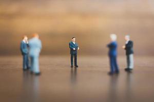 Businesspeople miniature debout sur un fond en bois photo