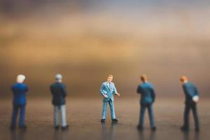 Businesspeople miniature debout sur un fond en bois photo