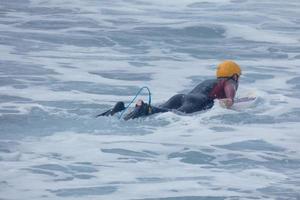 surfeurs avoir prêt à entrer le l'eau et en marchant avec le planche le long de le rive. photo