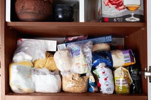 non organisé espace de rangement de céréales dans le cuisine armoire. macaroni, sucre, sarrasin, blé des balles dans sac Sacs. photo