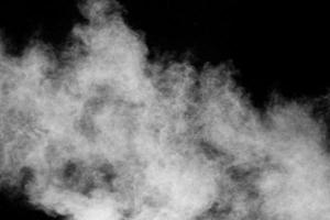 nuage de poussière blanche dans l'air. explosion de poudre blanche abstraite sur fond noir. photo