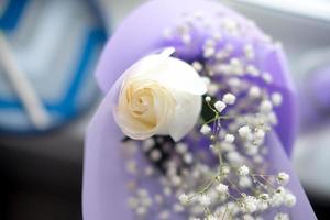 bouquet de blanc des roses dans violet emballage sur le rebord de fenêtre, Haut vue photo