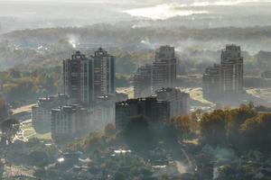 vue aérienne de la ville verte avec des gratte-ciel et des bâtiments résidentiels dans le brouillard et la brume photo