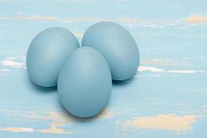 des œufs symbolisant le Pâques vacances dans bleu Couleur sur une Contexte de vieilli bois photo