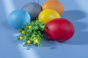 coloré œufs, symbolisant Pâques, sur une coloré Contexte et fleurs photo