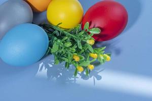 coloré œufs, symbolisant Pâques, sur une coloré Contexte et fleurs photo