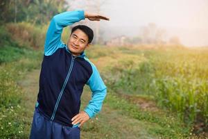 Beau asiatique homme entraînements Extérieur, corps élongation. chaud en haut avant ou cool vers le bas après exercer. concept, santé se soucier. sport.créatif activité. donner temps pour toi-même. photo