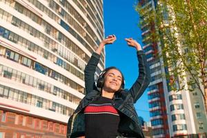 élégant décontractée branché branché femelle étudiant avec noir sans fil écouteurs photo