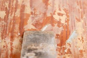 Nettoyage des portes de la vieille peinture avec une spatule, gros plan de réparation de restauration