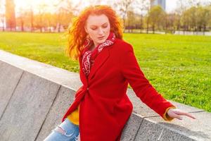 en plein air mode portrait Jeune élégant femme dans rouge manteau et Jaune chandail photo