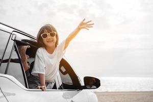 voyage en voiture à hayon conduite voyage en famille vacances d'été en voiture au coucher du soleil, filles heureuses voyageant profiter des vacances et de la détente ensemble obtenir l'atmosphère et aller à destination photo