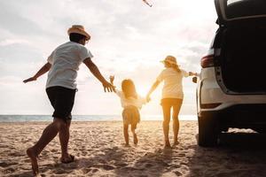 famille heureuse avec voyage en voiture. vacances d'été en voiture au coucher du soleil, papa, maman et fille heureux de voyager profitent ensemble de la conduite en vacances, les gens voyagent en automobile. photo