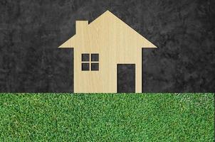 maison icône de en bois sur herbe texture la nature Contexte comme symbole de hypothèque, rêve maison sur la nature Contexte et espace pour votre texte photo