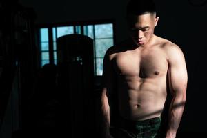 sexy corps de musclé Jeune soldat asiatique homme dans salle de sport. concept de santé se soucier, exercice aptitude, fort muscle masse, corps renforcement, graisse réduction pour Pour des hommes santé supplément produit présentation. photo