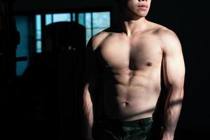 sexy corps de musclé Jeune soldat asiatique homme dans salle de sport. concept de santé se soucier, exercice aptitude, fort muscle masse, corps renforcement, graisse réduction pour Pour des hommes santé supplément produit présentation. photo