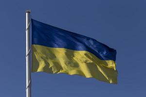 ukrainien Etat drapeau sur mât contre bleu ciel photo