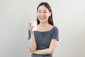 content, asiatique Jeune femme, fille en buvant une verre de blanc frais, chaud ou chaud laitier Lait pour calcium, vitamine sain bien nutrition dans Matin. mode de vie, produit en bonne santé personnes, isolé Contexte. photo