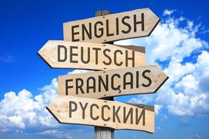 Anglais, Allemand, Français, russe - langues concept - en bois poteau indicateur avec quatre flèches photo