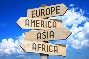L'Europe , Amérique, Asie, Afrique - continents, Voyage concept - en bois poteau indicateur avec quatre flèches photo