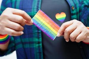 femme asiatique avec drapeau arc-en-ciel, droits des symboles lgbt et égalité des sexes, mois de la fierté lgbt en juin. photo