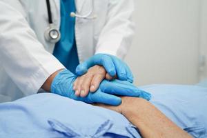 médecin tenant par la main une patiente âgée asiatique, aide et soins à l'hôpital. photo