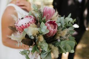 beau bouquet de mariage blanc avec mariée assise en arrière-plan - DOF peu profond photo