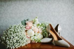 femelle pieds dans blanc mariage des sandales avec une bouquet de camomille photo