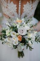 beau bouquet de mariage blanc avec mariée assise en arrière-plan - DOF peu profond photo