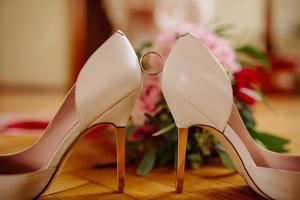 femelle pieds dans blanc mariage des sandales avec une bouquet de camomille photo