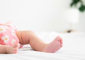 mignonne peu nouveau née bébé pieds sur lit à Accueil photo