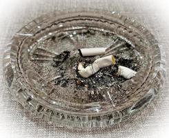 cigarette bout dans un cendrier sur le tableau. le concept de le les dangers de fumeur. photo