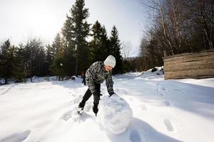 deux content garçons ensemble sculpter neige globe pour bonhomme de neige. frères Jeu Extérieur dans hiver avec neige dans montagnes. photo