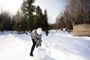 deux content garçons ensemble sculpter neige globe pour bonhomme de neige. frères Jeu Extérieur dans hiver avec neige dans montagnes. photo