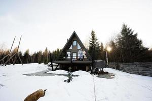 famille avec deux filles sur terrasse de la grille minuscule maison dans le montagnes. photo