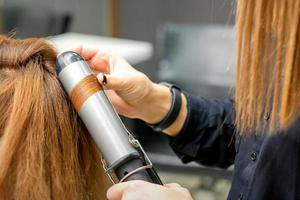 coiffeur fait du boucles avec curling le fer photo