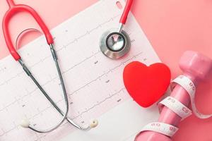 concept de santé cardiaque avec haltère rose et stéthescope photo