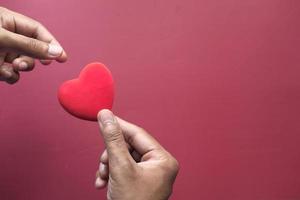 main de l'homme avec coeur sur fond rouge photo