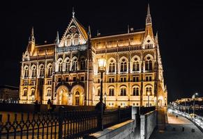 Le parlement hongrois à budapest sur le danube dans les veilleuses des lampadaires photo