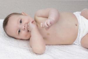 une six mois bébé garçon dans une couche mensonges sur une couche. le concept de maternité et paternité. photo