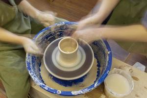 faïence sur une potier roue et le mains de une potier, flou dans mouvement. poterie entraînement. photo
