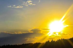 le coucher du soleil derrière forêt et des nuages dans Allemagne. photo