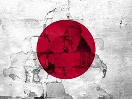 tremblements de terre dans Japon, drapeau Japon sur une mur avec des fissures de un tremblement de terre photo